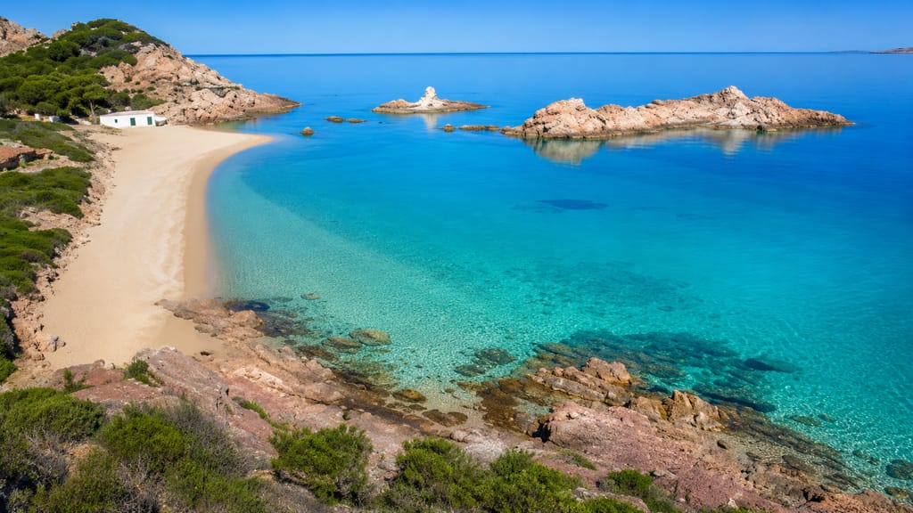 Arena dorada y rojiza de Cala Pregonda, norte de Menorca